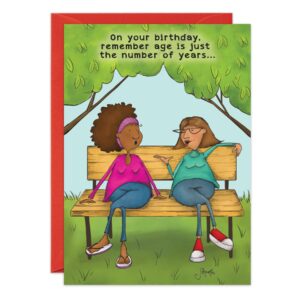Two women chat and smile on a park bench in a cheerful, colorful scene. The 9118.jpg birthday card reads, "On your birthday, remember age is just the number of years..." and comes with a red envelope.