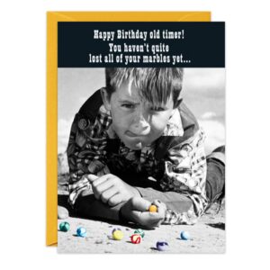 9169.jpg: A birthday card with a black-and-white photo of a boy playing marbles, captioned "Happy Birthday old timer! You haven’t quite lost your marbles yet..." Includes a yellow envelope.