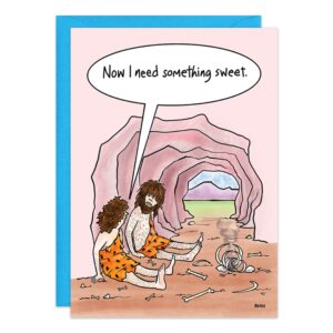 Cartoon of two cavemen in animal print outfits sitting by a fire and bones at a cave entrance. One says, "Now I need something sweet." A bright blue sky adds to this fun birthday card design. Product: 9402.jpg.