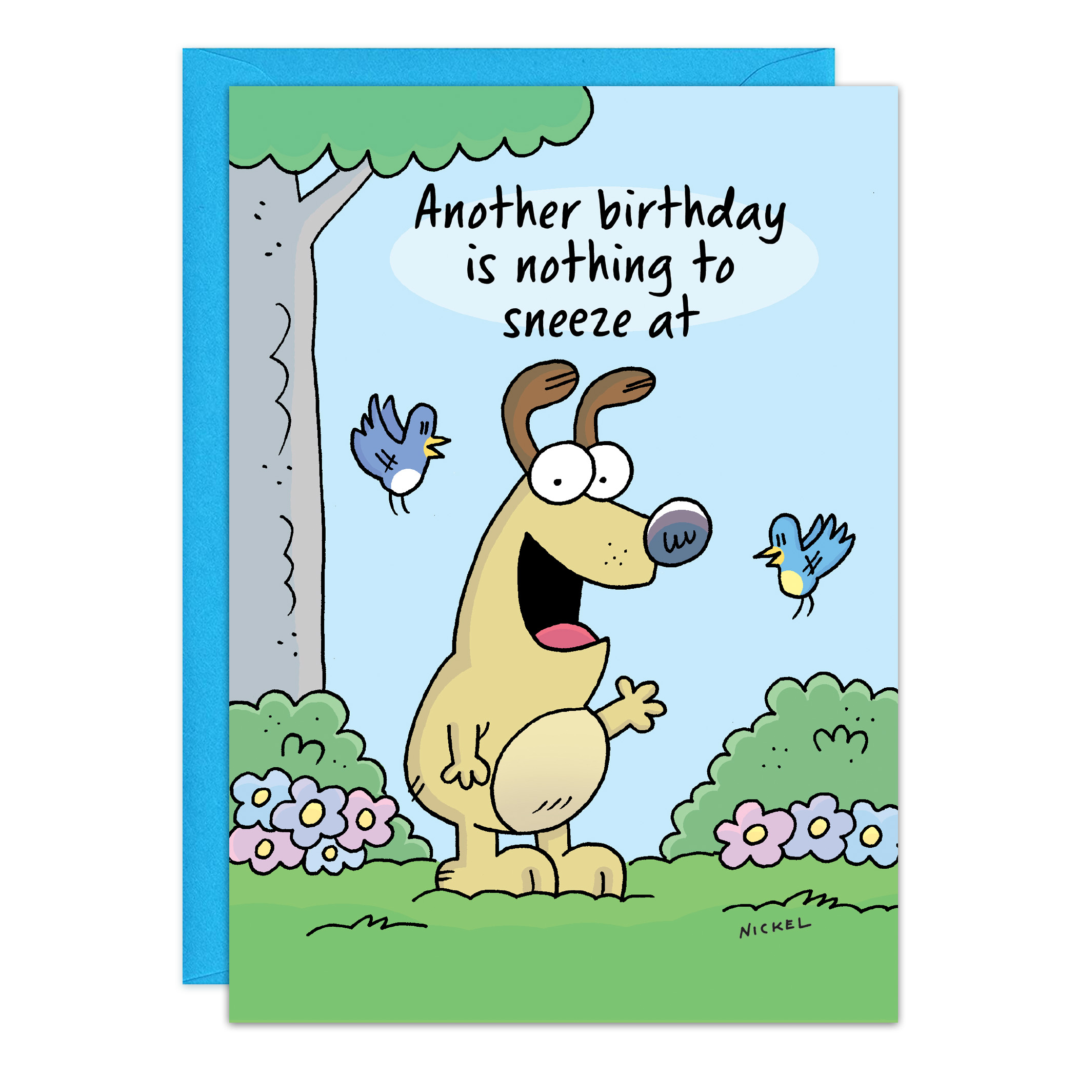A cartoon dog stands in grass, smiling with one paw up, next to two blue birds, flowers, and a tree. The card (9469) reads "Another birthday is nothing to sneeze at." A blue envelope sits behind the card.